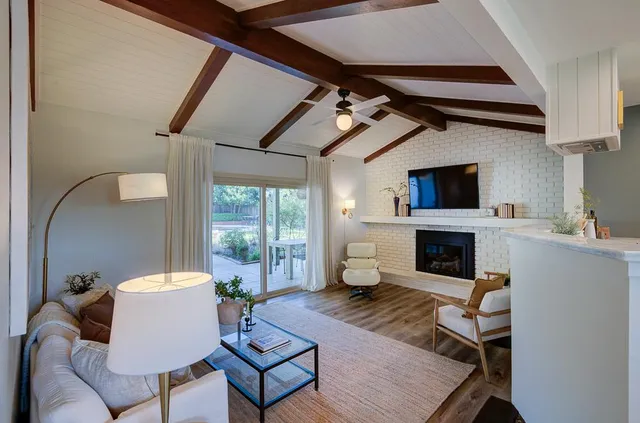 a living room with furniture a fireplace and a flat screen tv