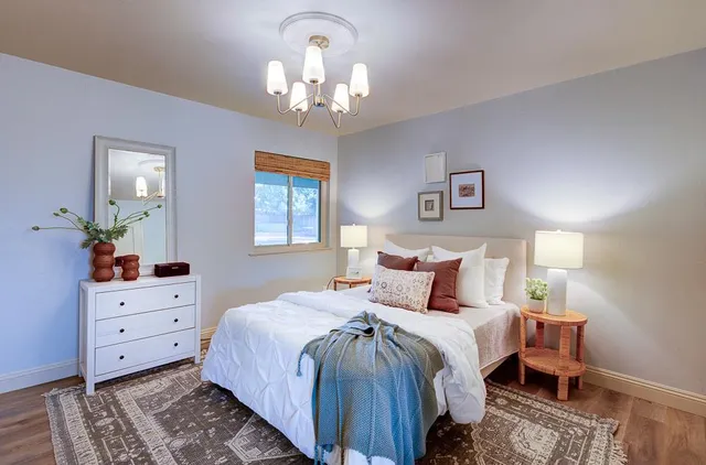 a bedroom with bed and wooden floor