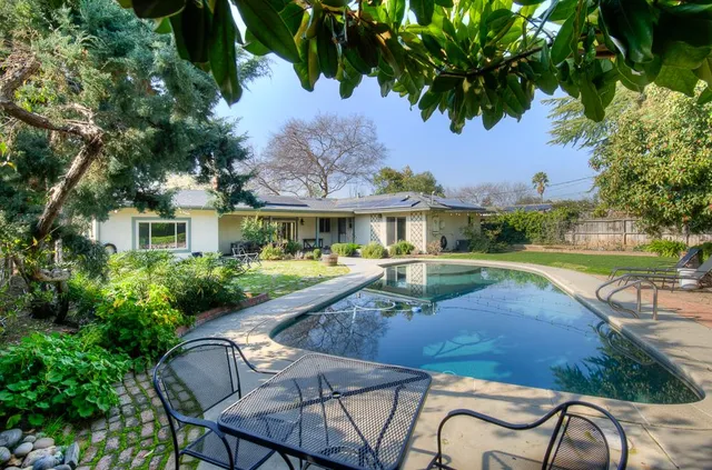 a view of a house with swimming pool and sitting area
