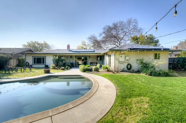 a view of a house with swimming pool and a yard