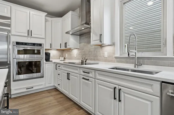 a kitchen with kitchen island granite countertop a sink a stove a refrigerator cabinets and dining table