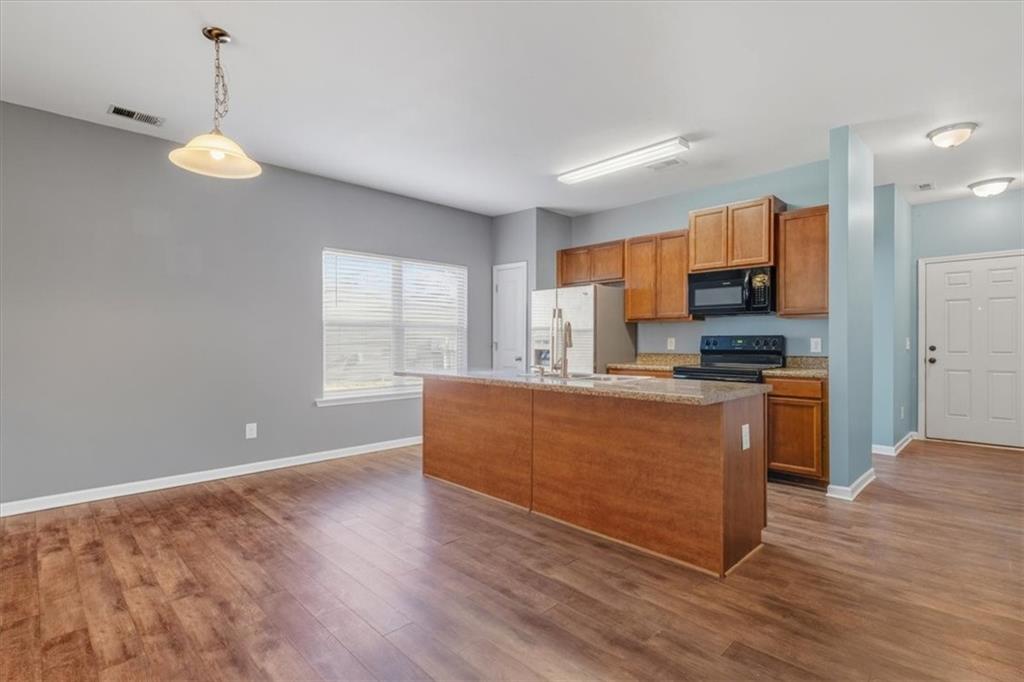 15 Grandberry Court Rome, GA 30165 - Photo 11 of 23 a large kitchen with stainless steel appliances granite countertop a stove a sink a refrigerator white cabinets and wooden floor