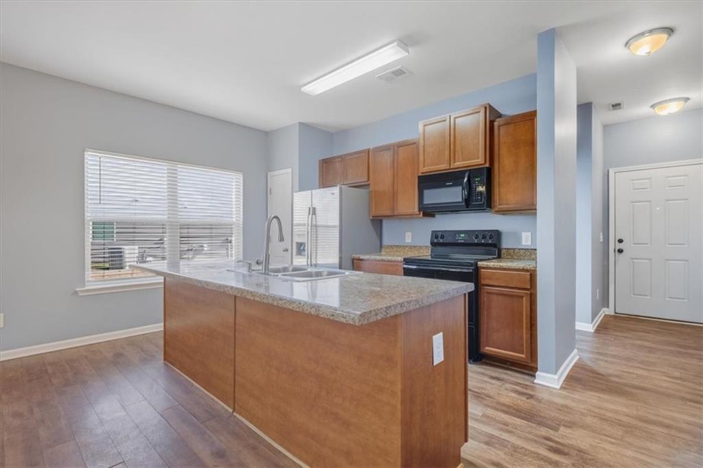 15 Grandberry Court Rome, GA 30165 - Photo 12 of 23 a kitchen with stainless steel appliances granite countertop a stove a sink a refrigerator and a granite counter tops with wooden floors