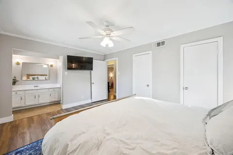 a bedroom with a large bed and a chandelier