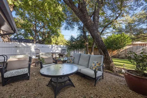 a view of patio with couches table and chairs and potted plants