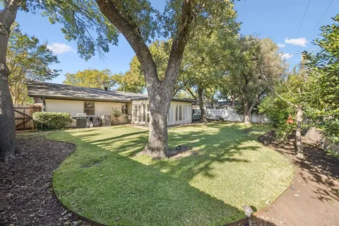 a view of a house with backyard and a tree