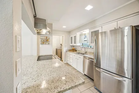 a kitchen with stainless steel appliances granite countertop a refrigerator and a sink