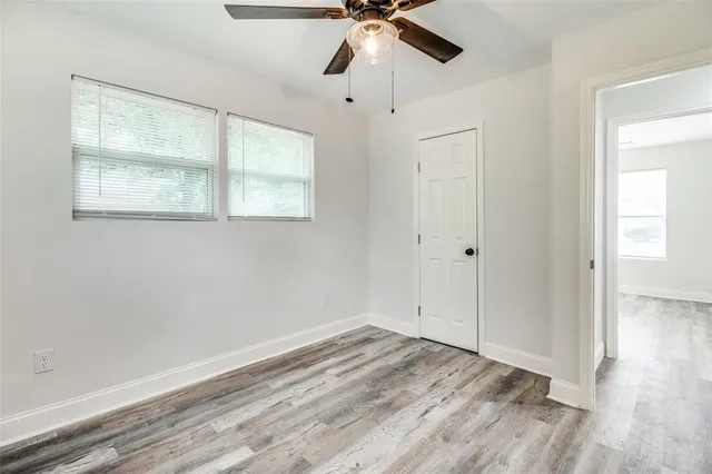 a view of empty room with window and ceiling fan