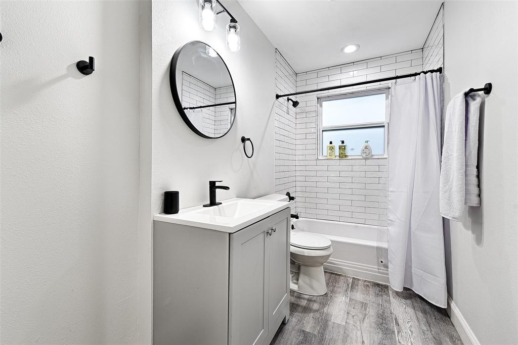 1201 Ridgewood Road Denison, TX 75020 - Photo 26 of 29 a bathroom with a sink a toilet and a mirror