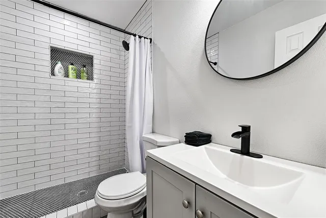 a bathroom with a sink a toilet and a mirror