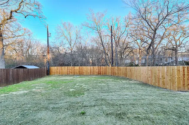 a view of backyard with wooden fence