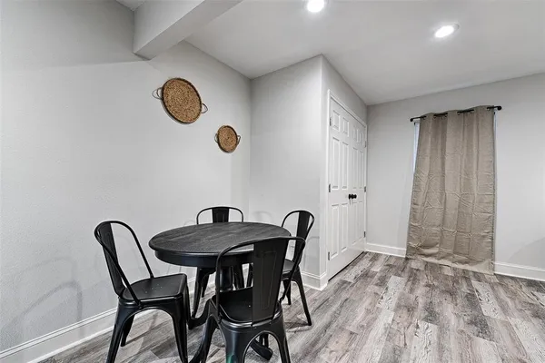 a view of a dining room and kitchen with a table chairs and wooden floor