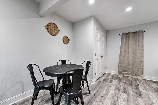 a view of a dining room and kitchen with a table chairs and wooden floor