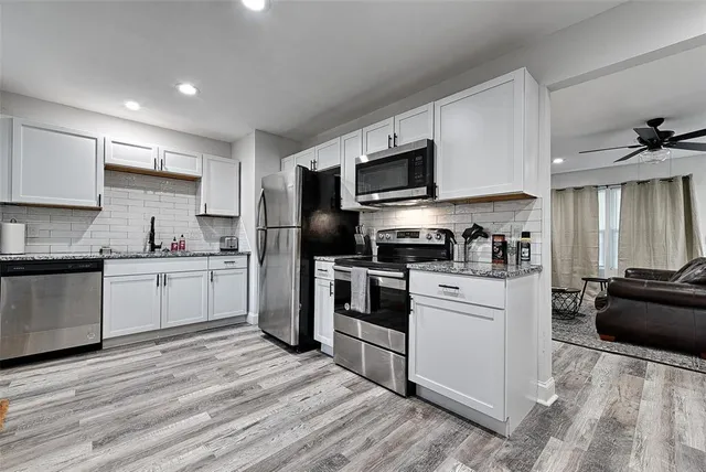 a kitchen with white cabinets stainless steel appliances and sink