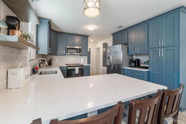 a kitchen with stainless steel appliances granite countertop a sink stove and microwave
