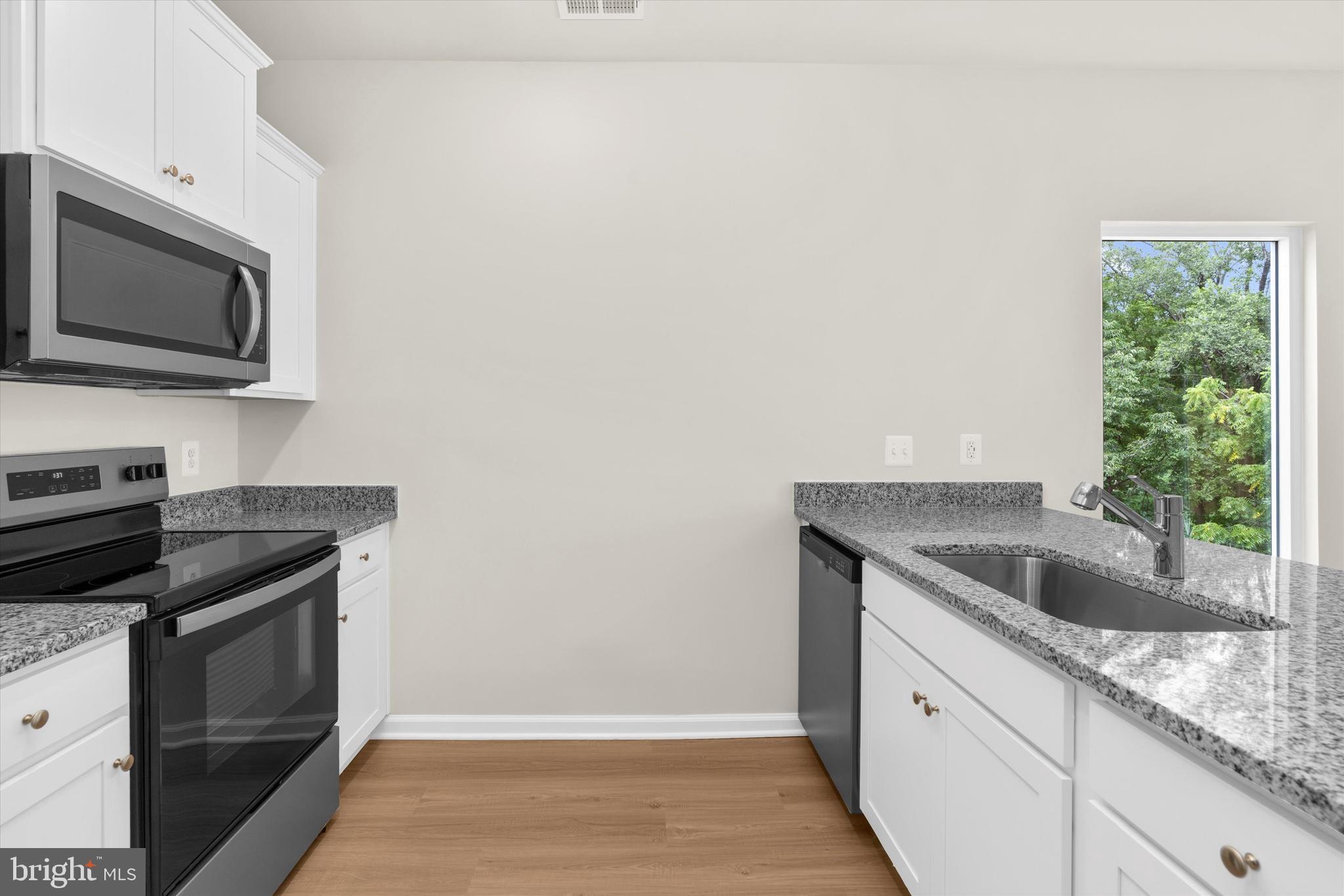 8135 Bartholomew Court Baltimore, MD 21206 - Photo 26 of 46 a kitchen with granite countertop a sink and a stove