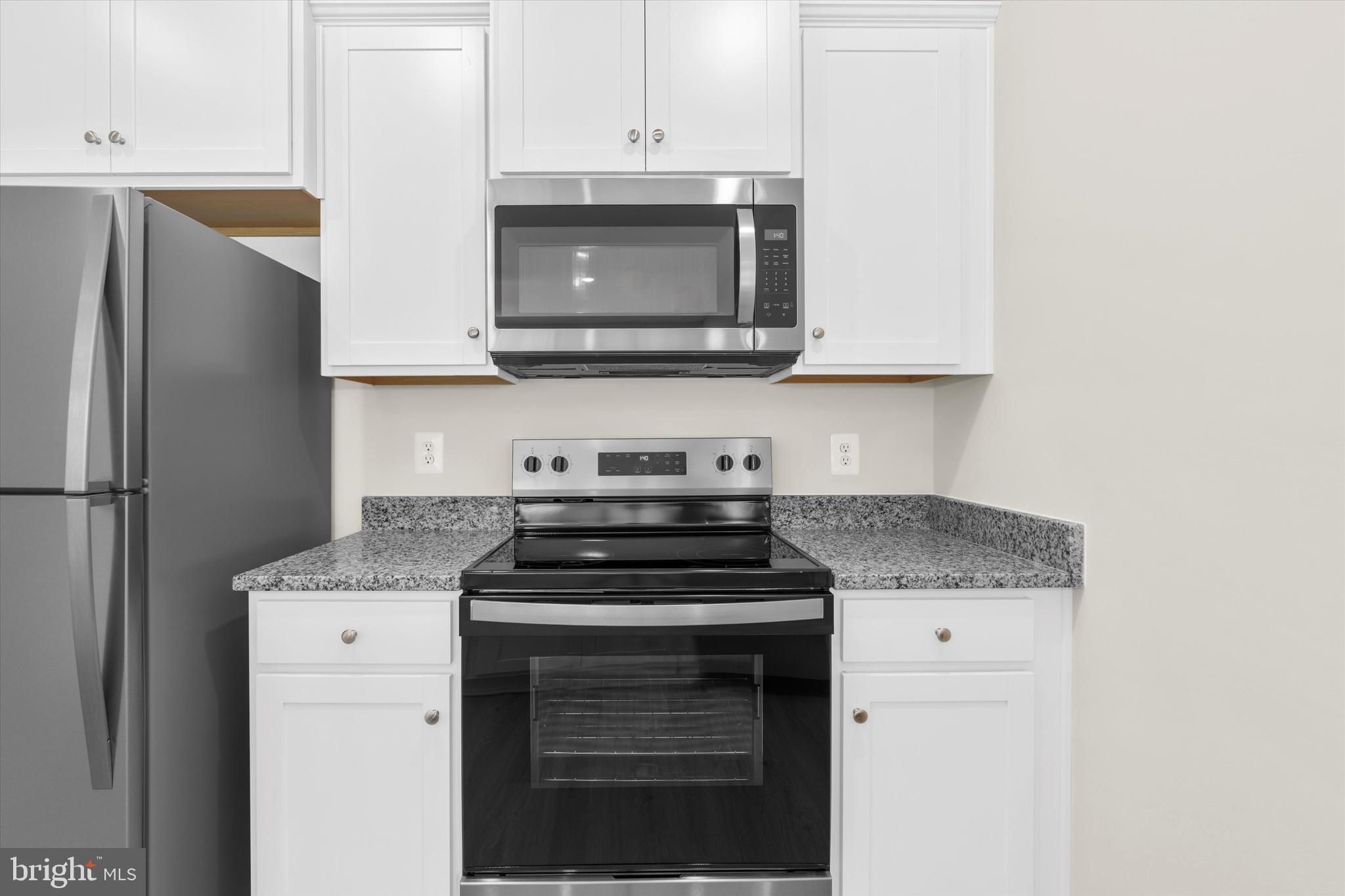8135 Bartholomew Court Baltimore, MD 21206 - Photo 28 of 46 a kitchen with stainless steel appliances granite countertop a stove and a microwave