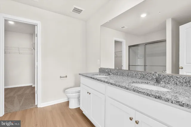 a bathroom with a granite countertop sink toilet and shower