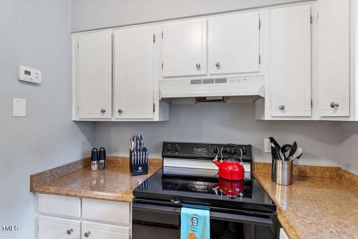712 Godwin Court Raleigh, NC 27606 - Photo 11 of 27 a kitchen with stainless steel appliances granite countertop a sink a stove and white cabinets