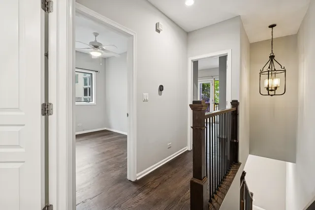 a view of a hallway with wooden floor and staircase