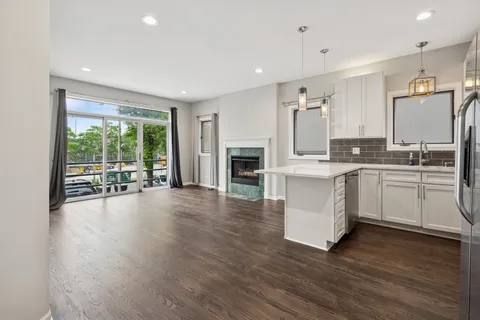 a large white kitchen with a large window a sink and stainless steel appliances