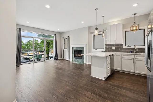 a large white kitchen with a large window a sink and stainless steel appliances