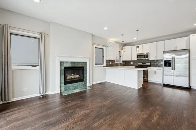a view of kitchen with granite countertop stainless steel appliances and wooden cabinets