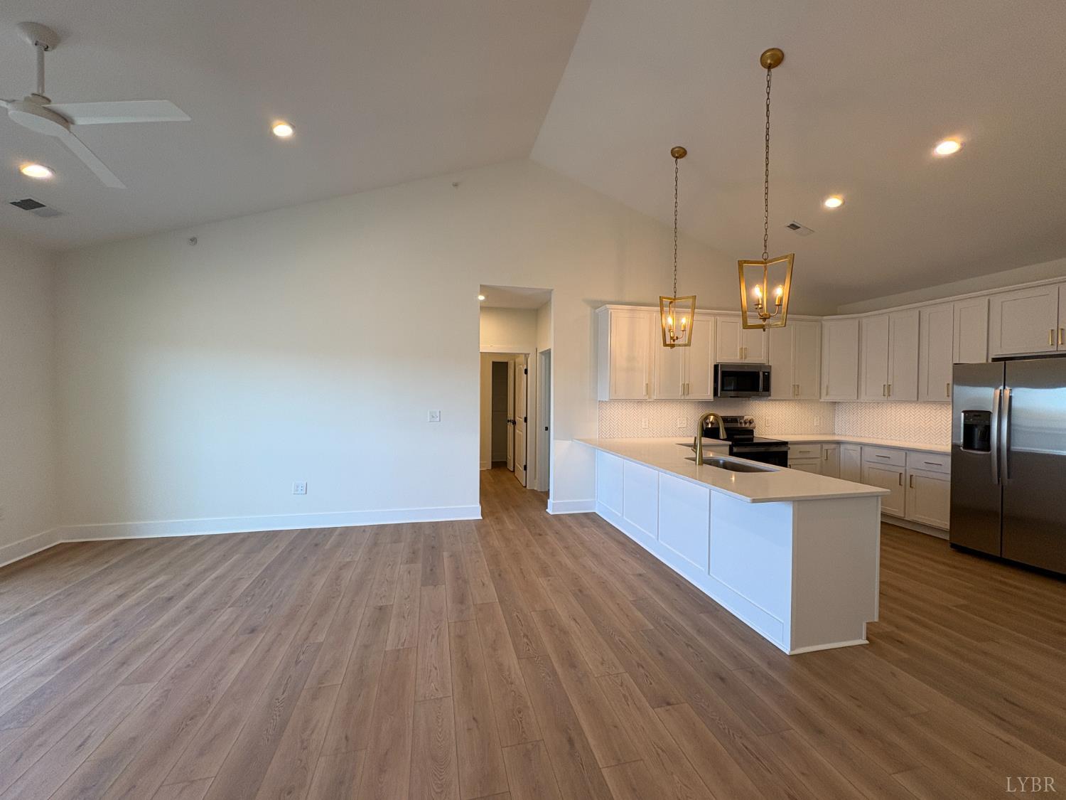 420 Capstone Drive, Unit 306 Lynchburg, VA 24502 - Photo 18 of 37 a large kitchen with stainless steel appliances a large counter top a wooden floors and a fireplace