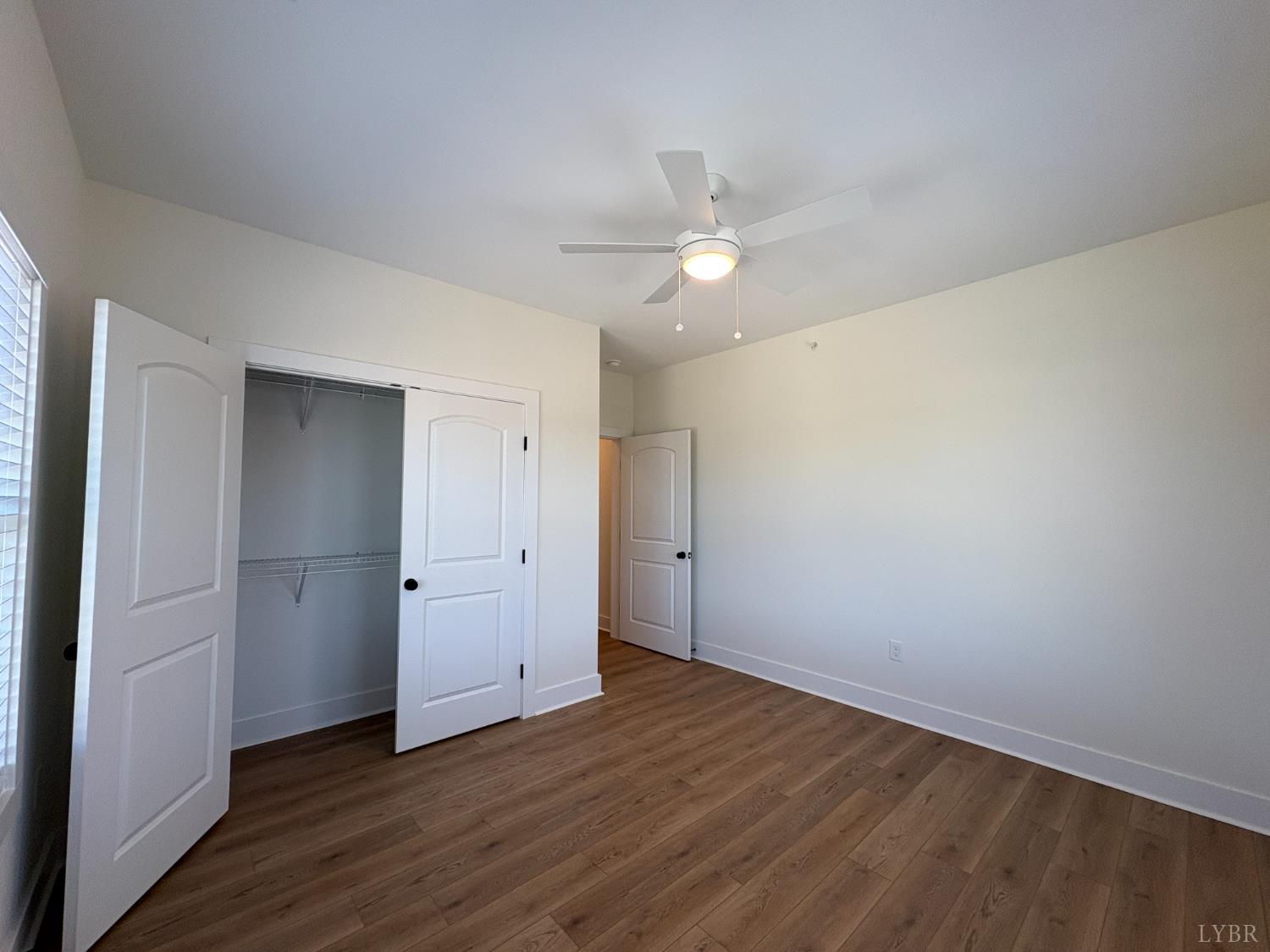 420 Capstone Drive, Unit 306 Lynchburg, VA 24502 - Photo 24 of 37 an empty room with wooden floor and ceiling fan