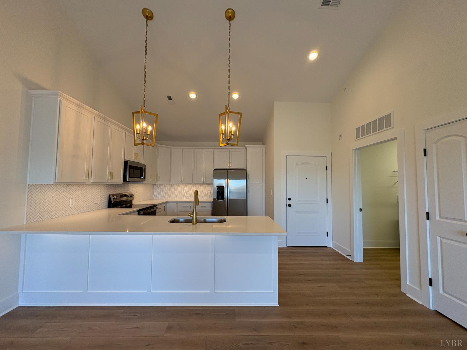 420 Capstone Drive, Unit 306 Lynchburg, VA 24502 - Photo 3 of 37 a kitchen with kitchen island stainless steel appliances a stove a sink cabinets and wooden floor