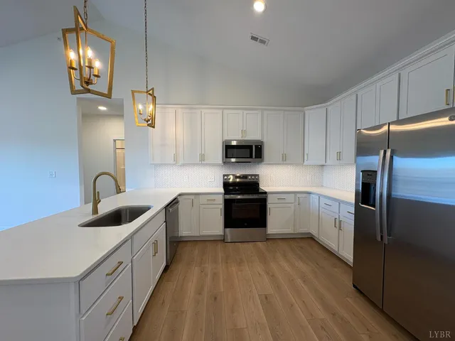 a kitchen with kitchen island granite countertop stainless steel appliances cabinets a sink and a stove