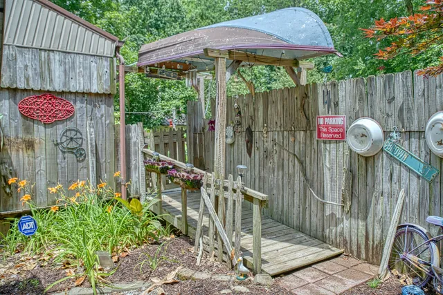 a view of backyard with potted plants and large tree
