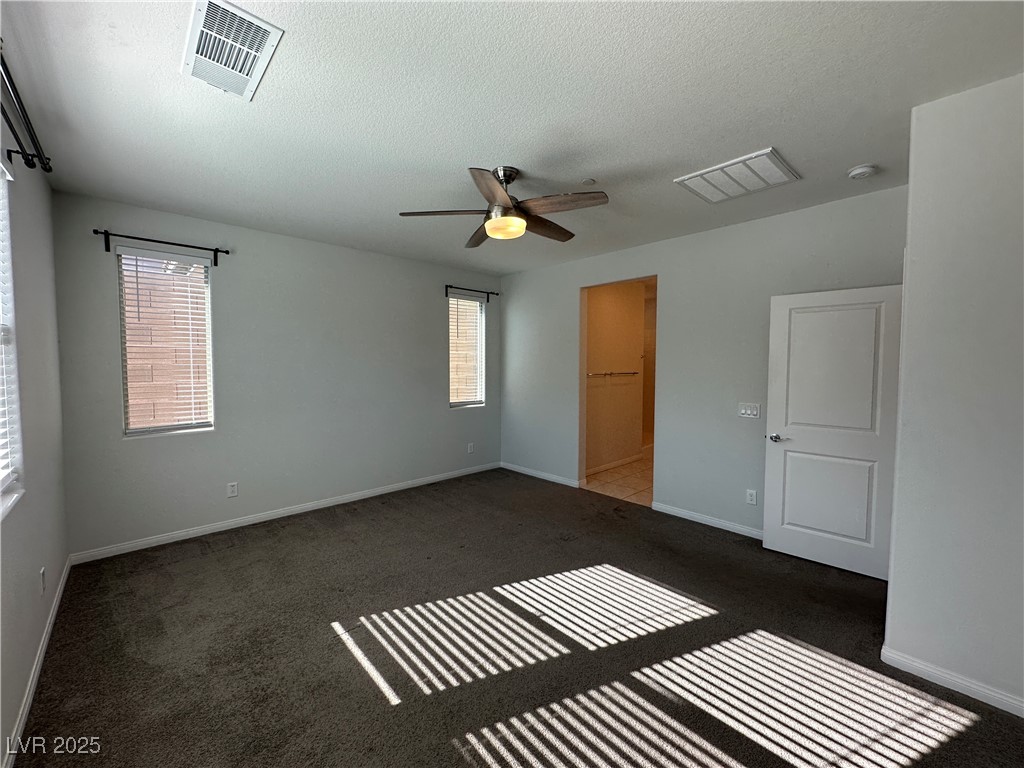 11585 Salt Creek Avenue Las Vegas, NV 89138 - Photo 13 of 45 Unfurnished bedroom featuring dark carpet, a textured ceiling, and ceiling fan