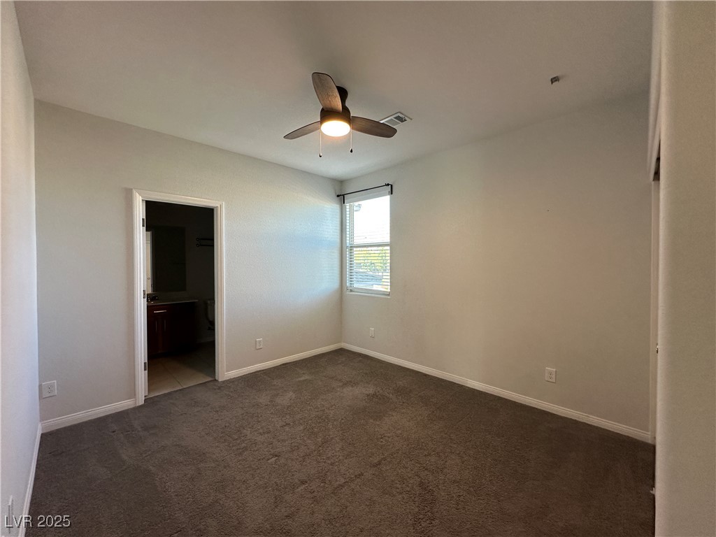 11585 Salt Creek Avenue Las Vegas, NV 89138 - Photo 26 of 45 Unfurnished bedroom with dark carpet, ceiling fan, and ensuite bath