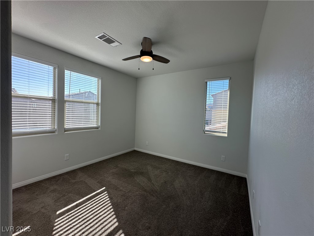 11585 Salt Creek Avenue Las Vegas, NV 89138 - Photo 36 of 45 Spare room featuring dark carpet, a textured ceiling, and ceiling fan