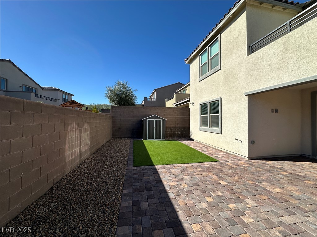 11585 Salt Creek Avenue Las Vegas, NV 89138 - Photo 43 of 45 Fenced backyard featuring a shed, a patio area, and a residential view