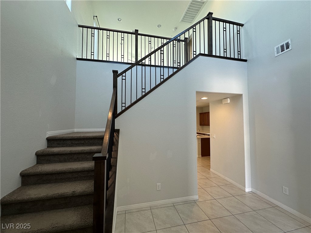 11585 Salt Creek Avenue Las Vegas, NV 89138 - Photo 5 of 45 Stairway with tile patterned floors, a high ceiling, and recessed lighting
