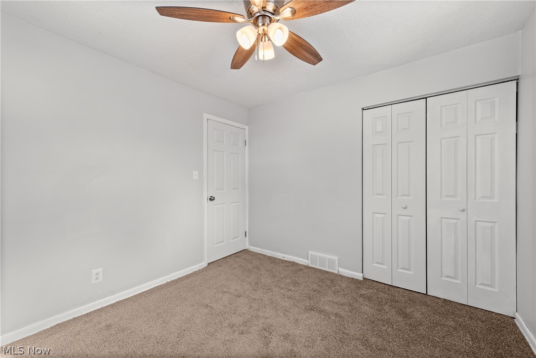 8760 Priem Road Strongsville, OH 44149 - Photo 12 of 29 Unfurnished bedroom featuring a closet, ceiling fan, and carpet