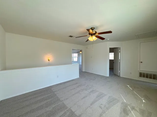 an empty room with closet and ceiling fan