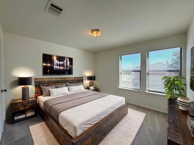 a bedroom with a bed and a potted plant