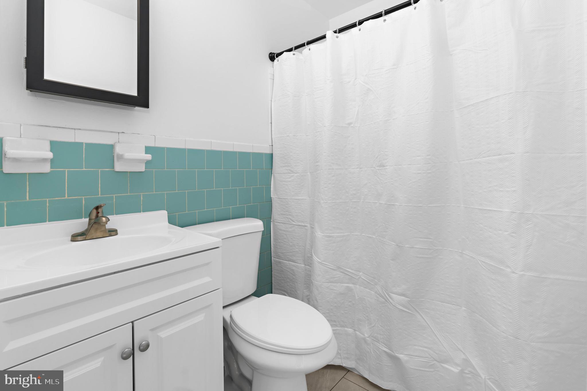 615 Bywater Road Annapolis, MD 21401 - Photo 23 of 28 a bathroom with a sink a toilet and shower curtain
