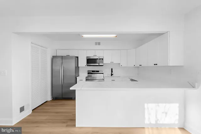 a kitchen with stainless steel appliances a refrigerator sink and microwave