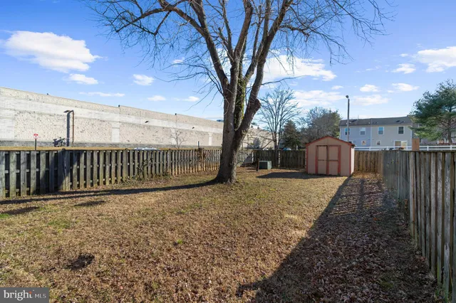 a view of a yard with wooden fence