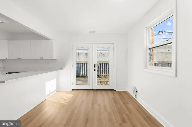 a view of a kitchen with a fridge wooden floor and a window
