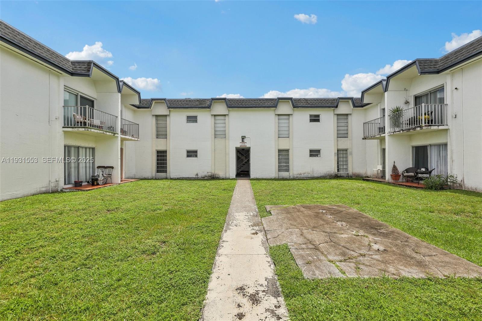 7232 Southwest 94th Place, Unit E6 Miami, FL 33173 - Photo 29 of 31 a view of a big house with a big yard and large tree