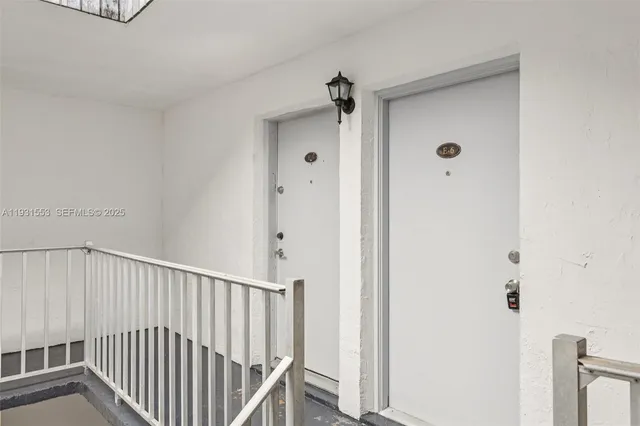 a view of a hallway with a white cabinet and door