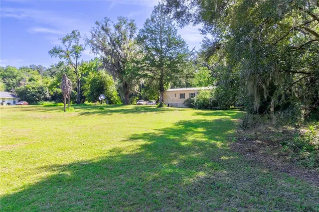 a view of a small house with yard