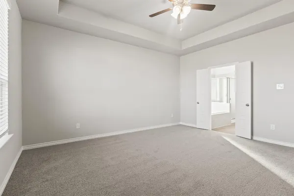 an empty room with a ceiling fan and a window