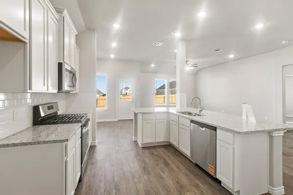 a kitchen with white cabinets appliances and sink