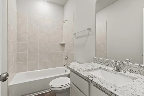 a bathroom with a granite countertop sink a toilet and bathtub